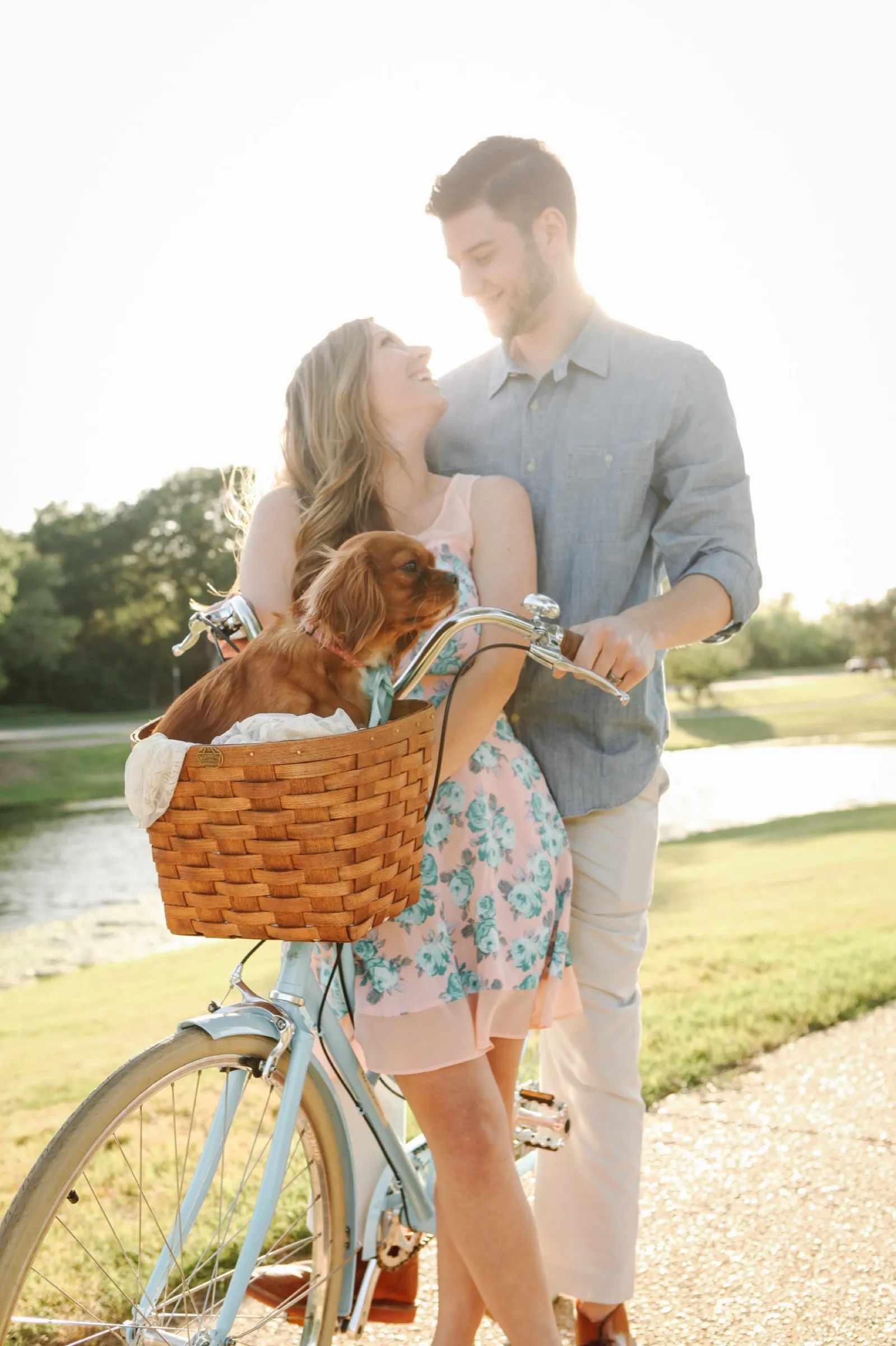 Cole and Caitlin Edwards on a vintage blue bike with a basket during golden hour